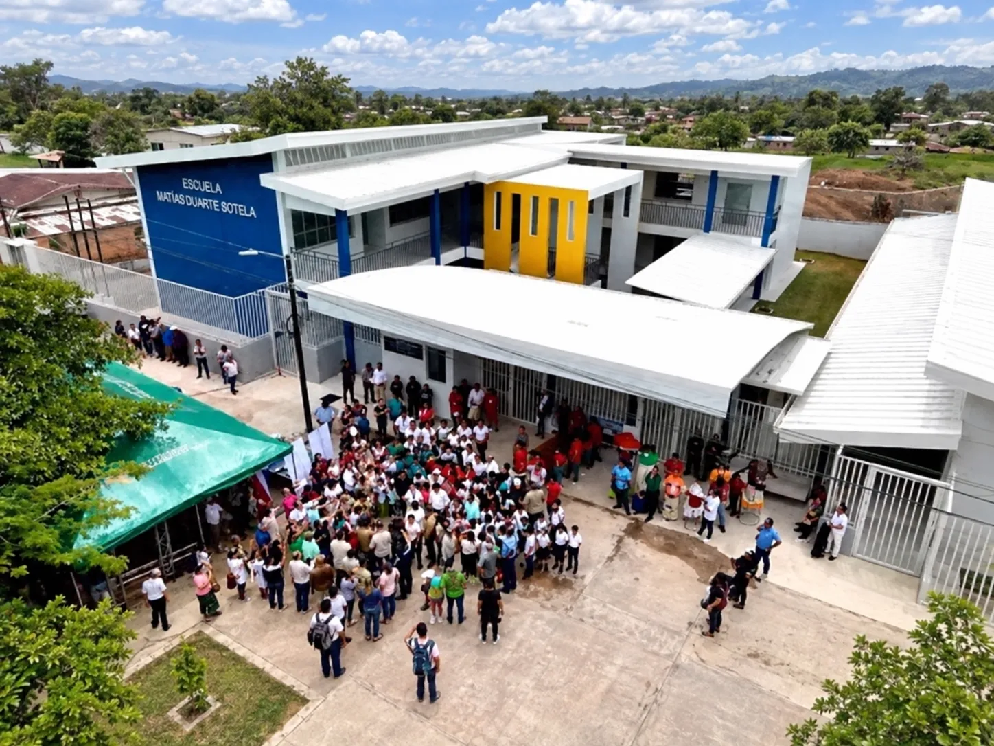Vista aérea de la Escuela Matías Duarte Sotela recién construida, con la comunidad reunida en el patio durante la inauguración