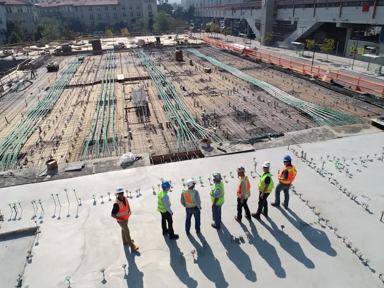 Personal de obra con chaleco reflectivo y casco durante la ejecución de un proyecto