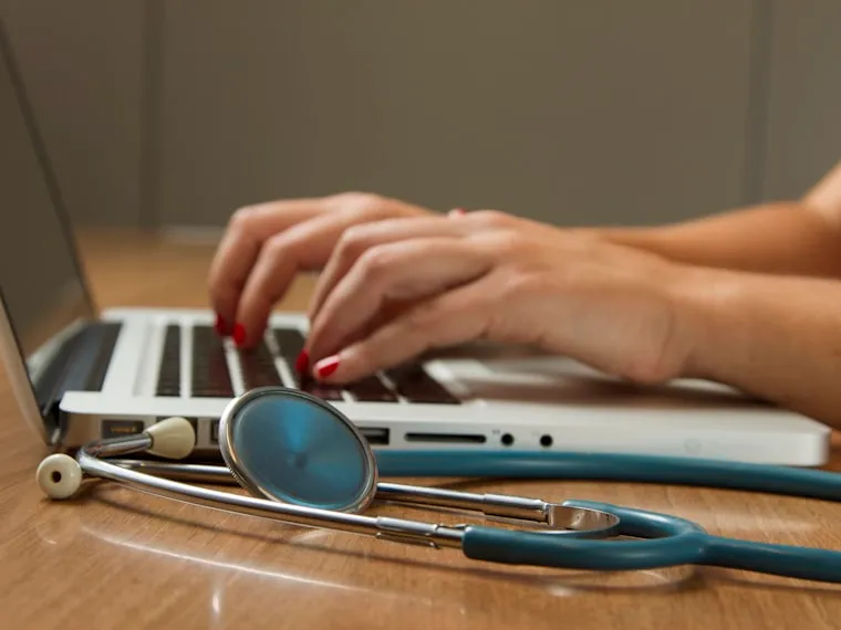 Escritorio con estetoscopio mientras se registran datos de vigilancia de la salud